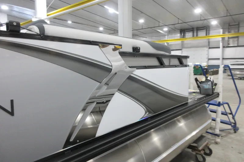 Slide: The Image of 2025 Avalon LSZ Quad Lounger pontoon boat in a modern indoor facility. - 12