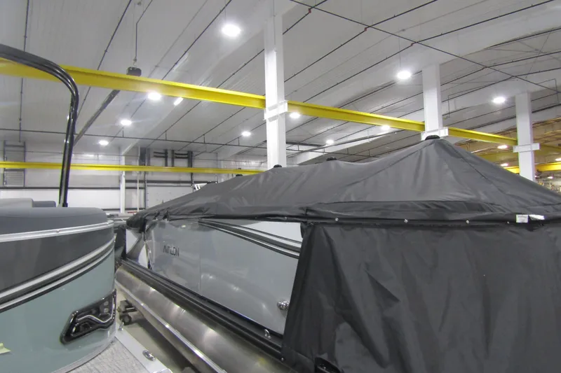Slide: The Image of 2025 Avalon LSZ Quad Lounger boat covered in a warehouse setting. - 14