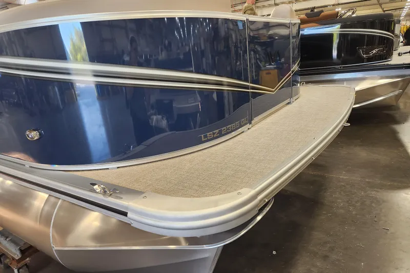 Slide: The Image of 2026 Avalon LSZ Quad Lounger pontoon boat in showroom, featuring sleek design and spacious deck. - 11