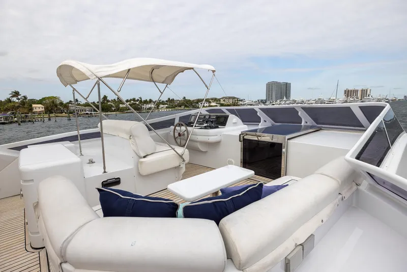 Slide: The Image of Luxurious 1999 Azimut 100 Jumbo yacht deck with seating and helm, featuring a canopy. - 14