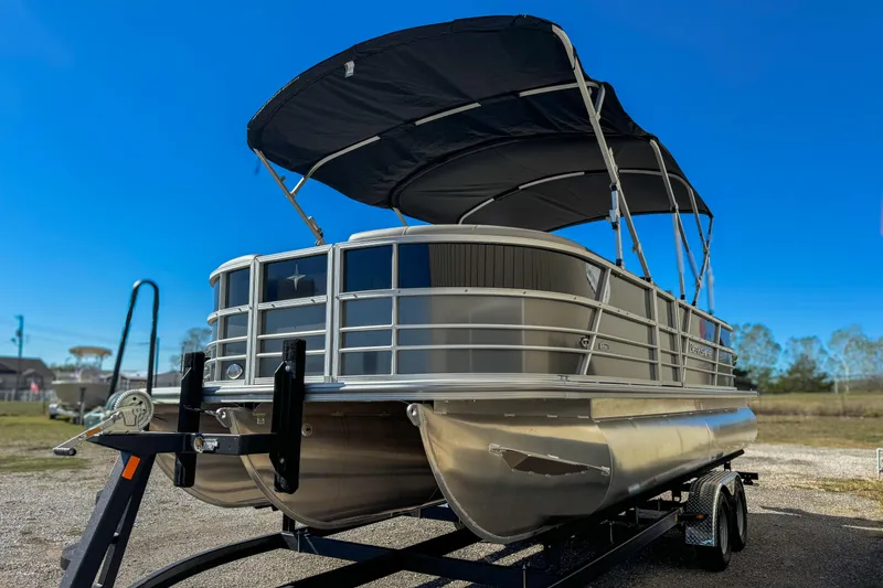 Slide: The Image of 2024 Berkshire 24RFX LE pontoon boat with canopy on trailer, under clear blue sky. - 2