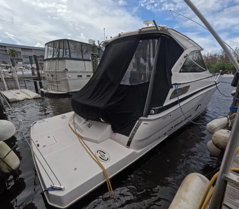 Slide: The Image of 2015 Regal 35 Sport Coupe docked at marina, covered with black tarp. - 13
