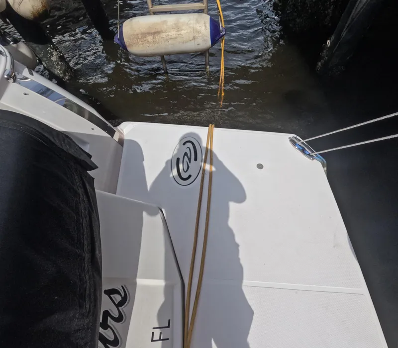 Slide: The Image of 2015 Regal 35 Sport Coupe boat docked with fender and rope visible. - 26