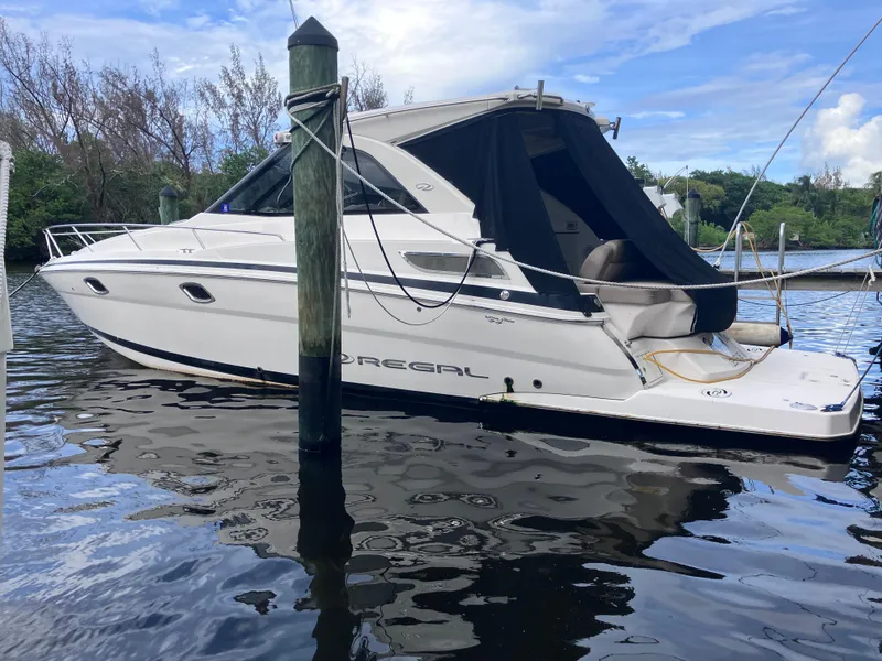 Slide: The Image of 2015 Regal 35 Sport Coupe boat docked on calm water. - 3