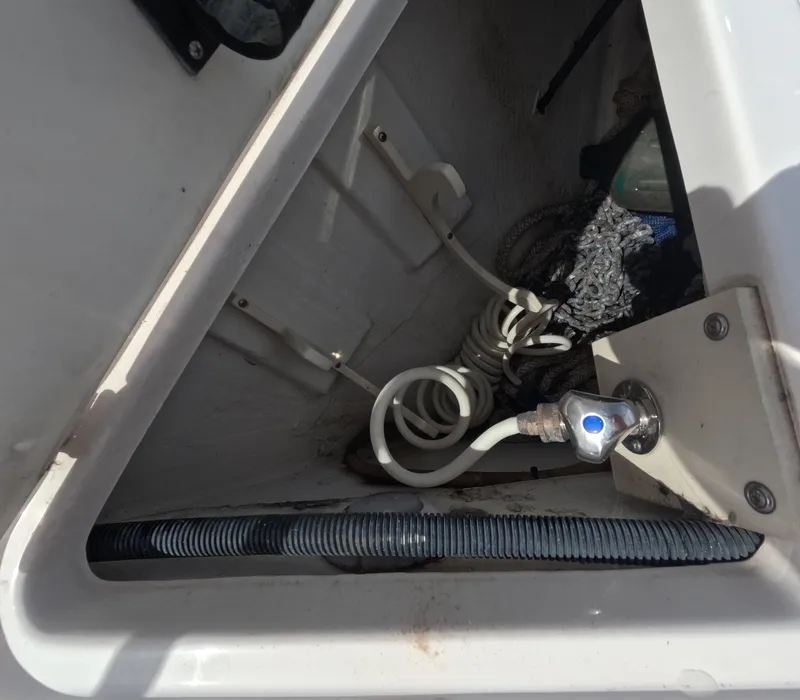 Slide: The Image of 2015 Regal 35 Sport Coupe storage compartment with coiled hose and fittings. - 33