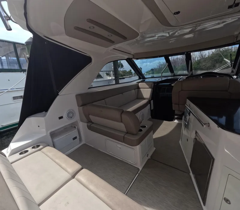 Slide: The Image of Interior of a 2015 Regal 35 Sport Coupe boat with beige seating and modern amenities. - 38