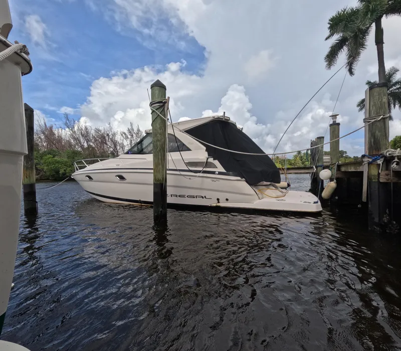 Slide: The Image of 2015 Regal 35 Sport Coupe docked in a scenic marina setting. - 4