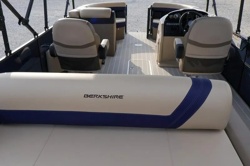 Slide: The Image of 2024 Berkshire 24UL CTS pontoon boat interior with beige seating and steering console. - 16