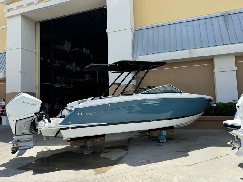Slide: The Image of 2023 Cobalt R8 Outboard boat displayed outside a building. - 2