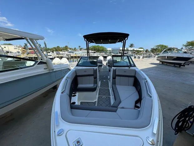 Slide: The Image of 2023 Cobalt R8 Outboard boat with sleek design and spacious seating at a marina. - 34
