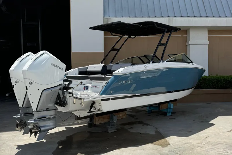 Slide: The Image of 2023 Cobalt R8 Outboard boat with dual Mercury engines, docked outdoors. - 4