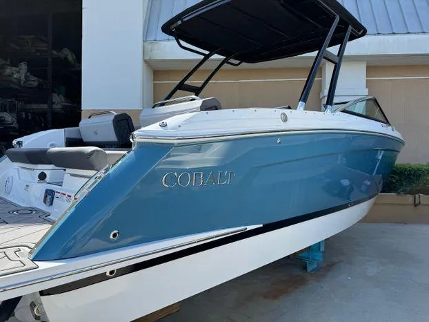 Slide: The Image of 2023 Cobalt R8 Outboard boat with blue hull and black canopy. - 9