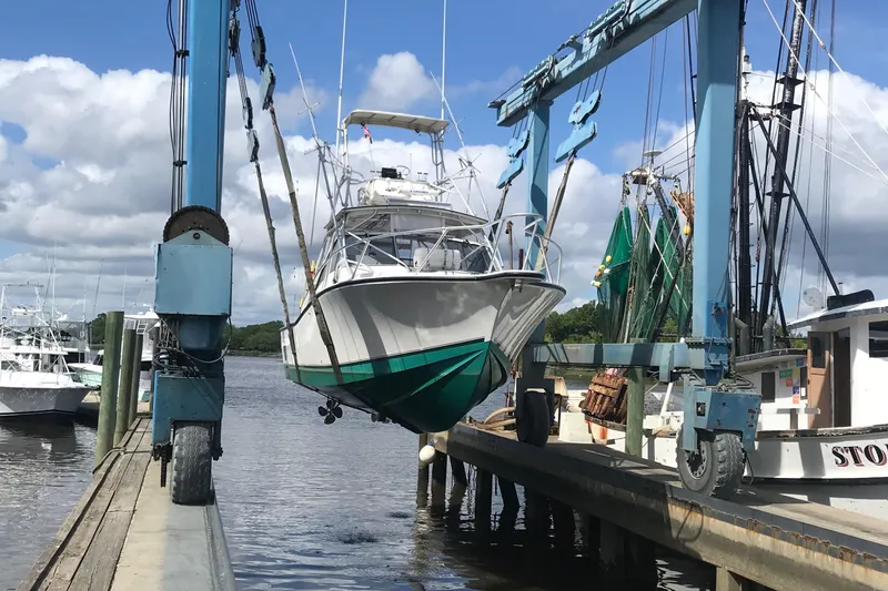 Slide: The Image of 1998 Albemarle 320 Express Fisherman boat being lifted at a marina. - 2