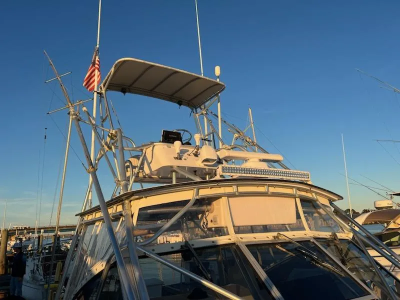 Slide: The Image of 1998 Albemarle 320 Express Fisherman boat with American flag, docked under clear sky. - 23