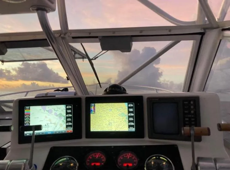 Slide: The Image of 1998 Albemarle 320 Express Fisherman cockpit with navigation screens at sunset. - 29