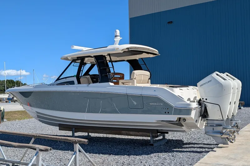 The Image of 2024 Boston Whaler 350 Realm boat with triple Mercury engines, docked outdoors. - 0