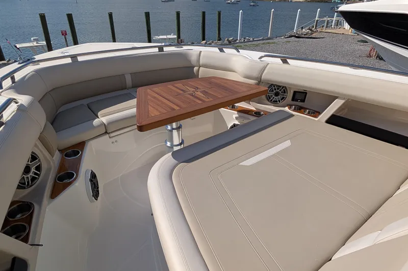 Slide: The Image of Luxurious seating area on 2024 Boston Whaler 350 Realm boat with wooden table and cup holders. - 14