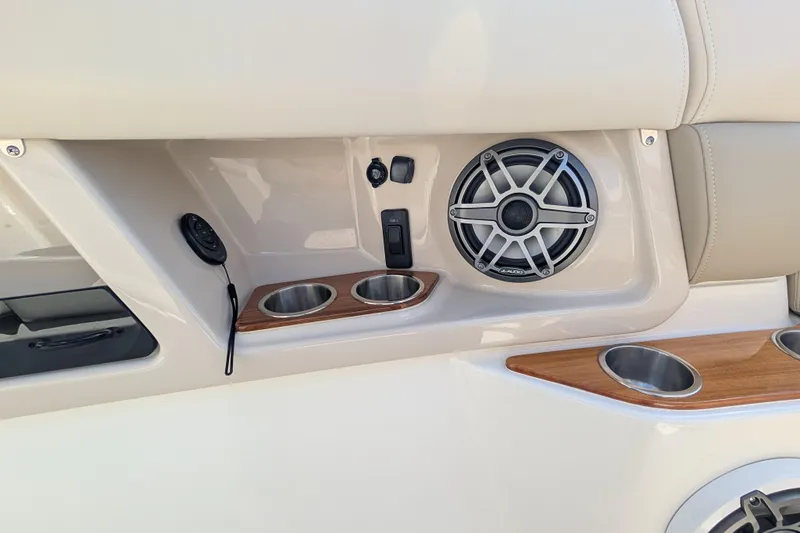 Slide: The Image of 2024 Boston Whaler 350 Realm interior with speaker, cup holders, and control panel. - 16