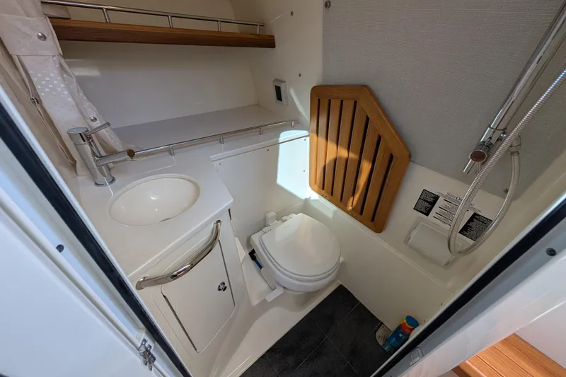 Slide: The Image of 2024 Boston Whaler 350 Realm boat bathroom with sink, toilet, and shower. - 28