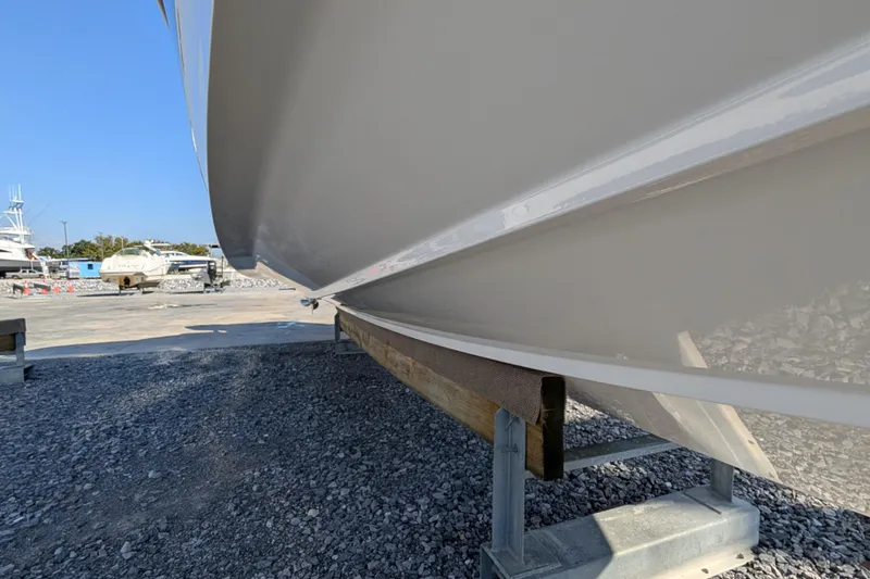 Slide: The Image of 2024 Boston Whaler 350 Realm boat hull on a stand, outdoor setting. - 38
