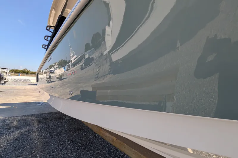 Slide: The Image of 2024 Boston Whaler 350 Realm boat hull reflecting surroundings in a marina setting. - 39