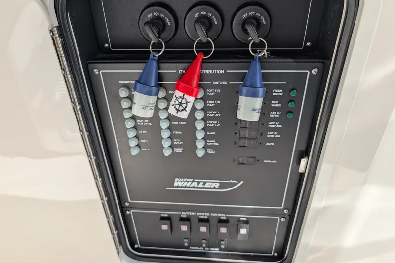 Slide: The Image of Control panel of 2024 Boston Whaler 350 Realm boat with labeled switches and keys. - 53