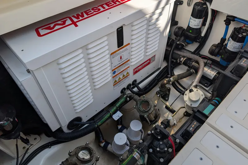 Slide: The Image of Engine compartment of 2024 Boston Whaler 350 Realm with Westerbeke generator and various components. - 54
