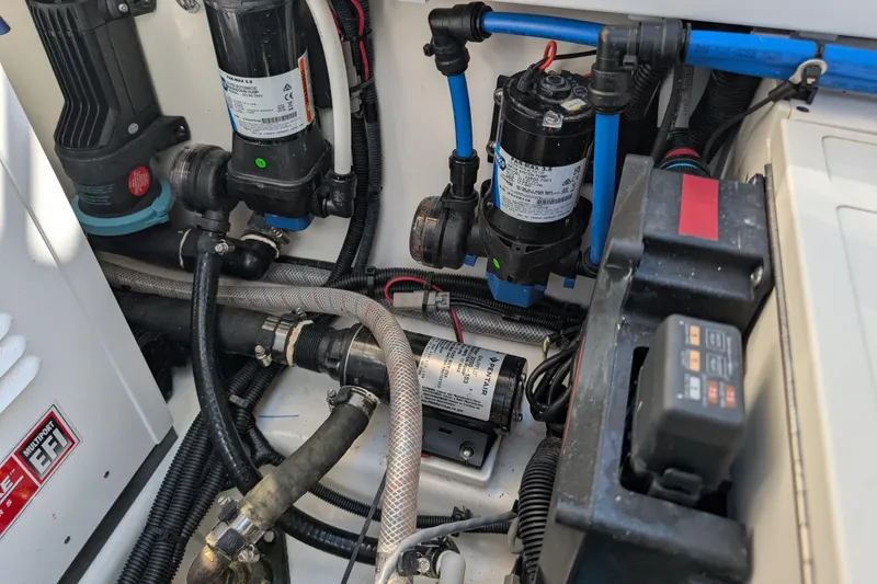 Slide: The Image of Engine compartment of 2024 Boston Whaler 350 Realm, showcasing pumps and wiring. - 55