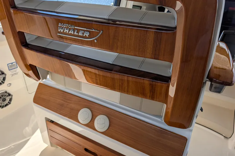 Slide: The Image of 2024 Boston Whaler 350 Realm interior with polished wood and branded detailing. - 9