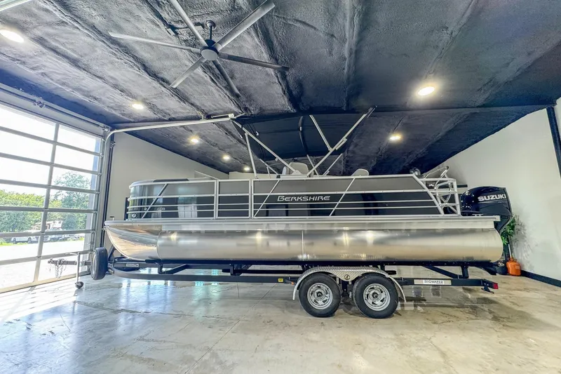 The Image of 2024 Berkshire 24UL LE B pontoon boat in a modern garage setting. - 1