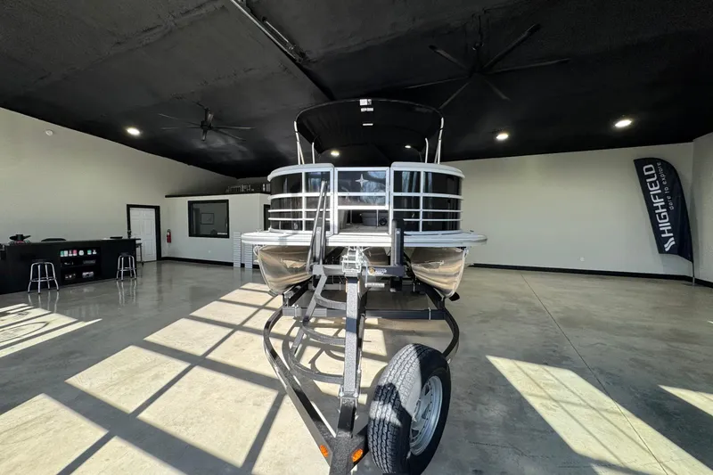 Slide: The Image of 2025 Berkshire 24RFC LE pontoon boat displayed indoors on a trailer. - 5