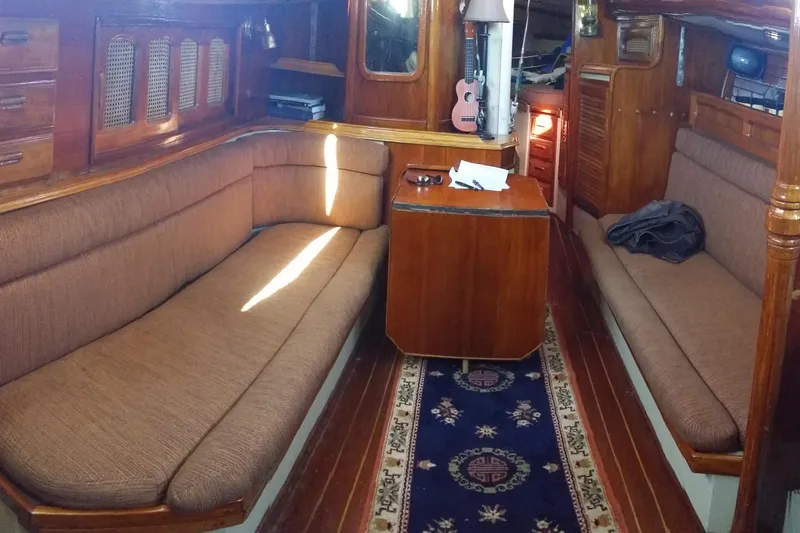 Slide: The Image of 1978 Islander 36 yacht interior with wooden furnishings and cozy seating area. - 11