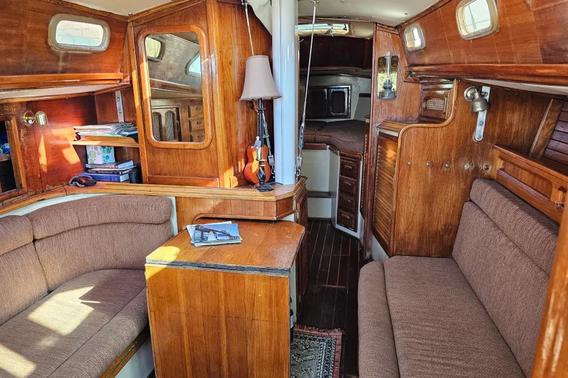 Slide: The Image of 1978 Islander 36 sailboat interior with wood finish and cozy seating area. - 12