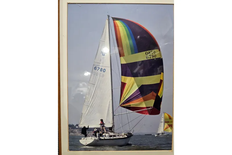 Slide: The Image of 1978 Islander 36 sailboat with colorful spinnaker sailing on open water. - 2