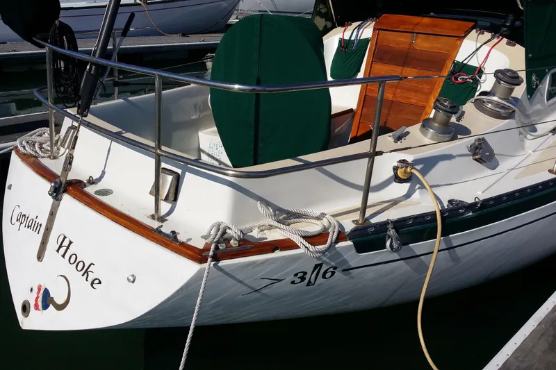 Slide: The Image of 1978 Islander 36 sailboat "Captain Hooke" docked, featuring wooden accents and nautical equipment. - 4