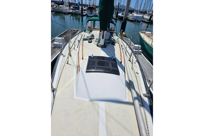 Slide: The Image of 1978 Islander 36 sailboat deck view at marina, surrounded by other boats. - 6