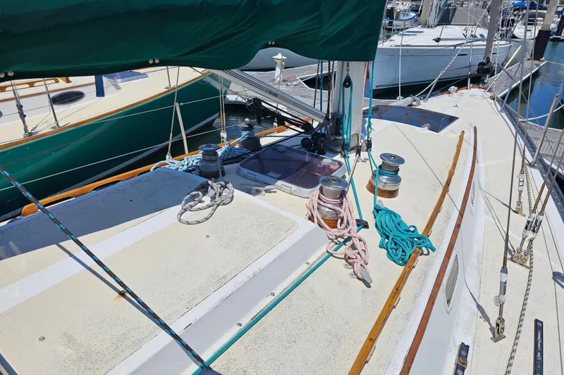 Slide: The Image of 1978 Islander 36 sailboat deck with ropes and winches in a marina. - 7