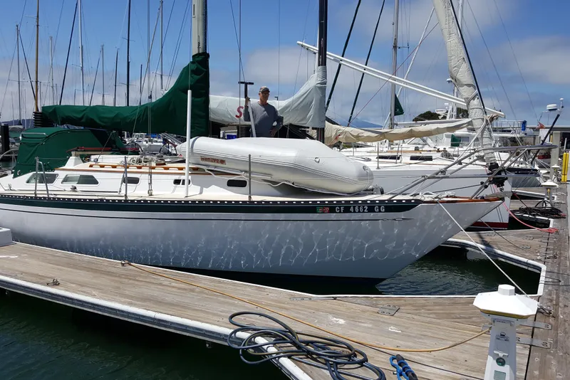 Slide: The Image of 1978 Islander 36 sailboat docked at marina with inflatable dinghy on deck. - 8