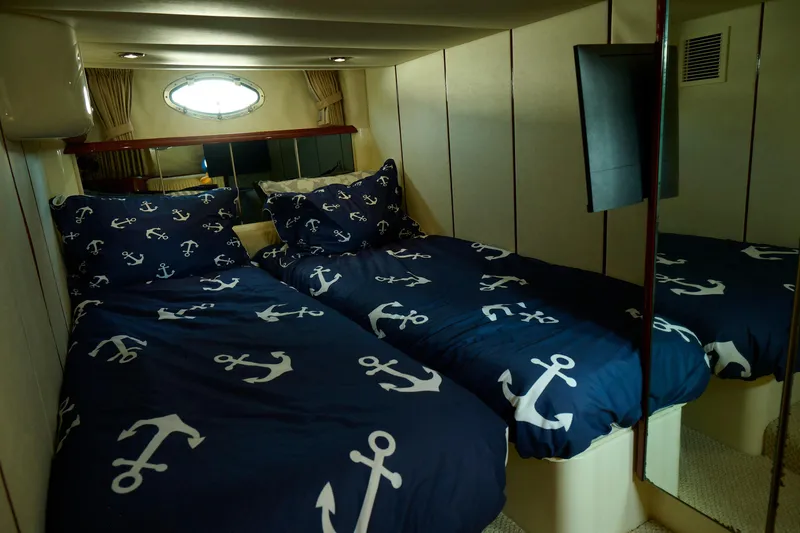 Slide: The Image of Cozy cabin bedroom in 2001 Fairline 43 yacht with nautical-themed bedding. - 26