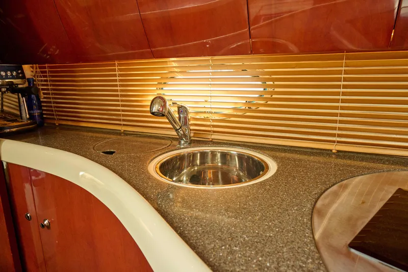Slide: The Image of Luxurious kitchen sink area on a 2001 Fairline 43 yacht with wooden cabinetry. - 28