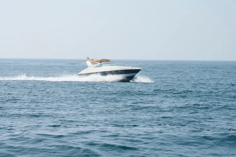 Slide: The Image of 2001 Fairline 43 yacht cruising on open sea under clear sky. - 9