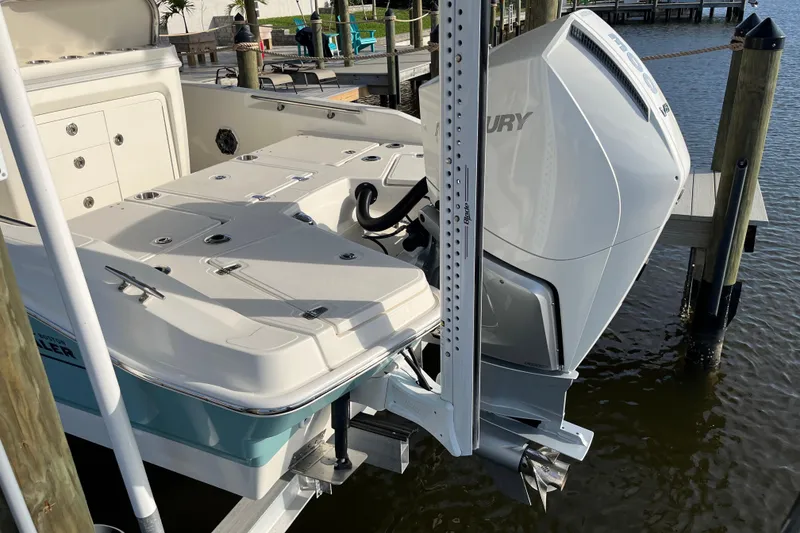 Slide: The Image of 2024 Boston Whaler 250 Dauntless boat with Mercury engine docked by the water. - 5