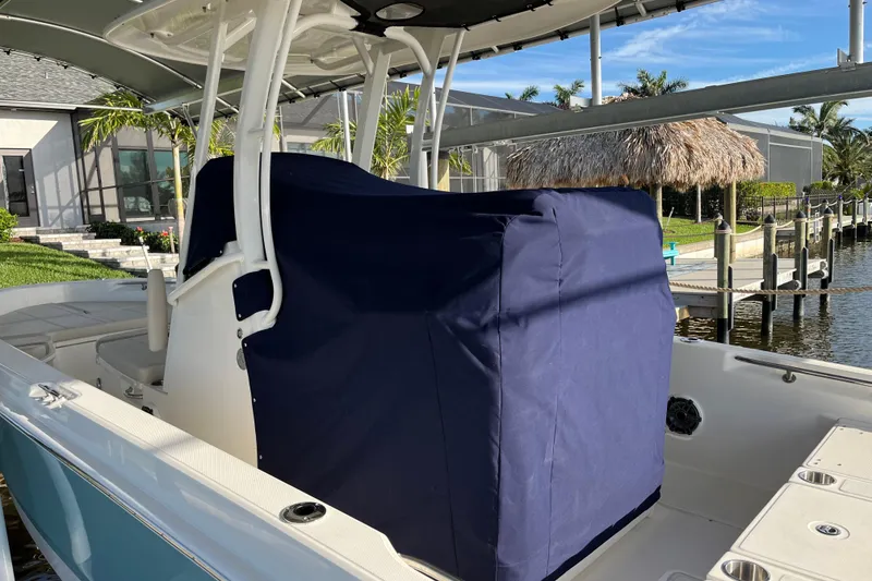 Slide: The Image of 2024 Boston Whaler 250 Dauntless boat with covered console, docked near waterfront home. - 6