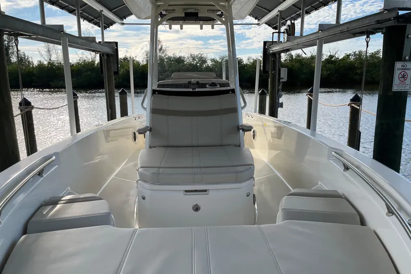 Slide: The Image of 2024 Boston Whaler 250 Dauntless boat interior, docked with scenic water view. - 8
