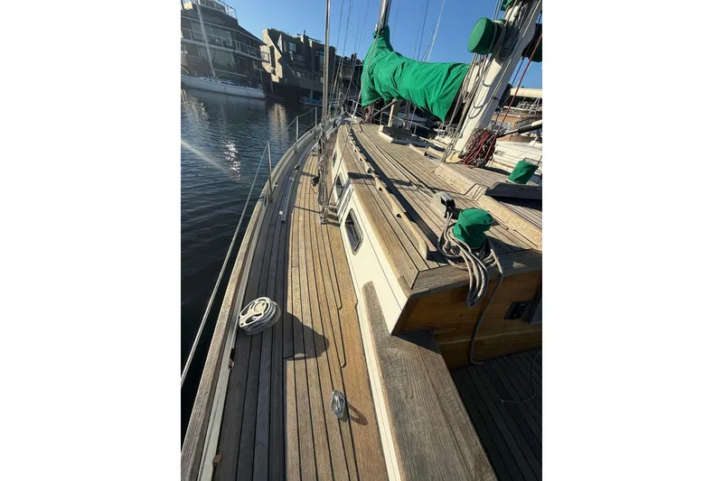 Slide: The Image of 49' Chuck Burns Custom Schooner, 2007, docked with green sail covers and wooden deck. - 14