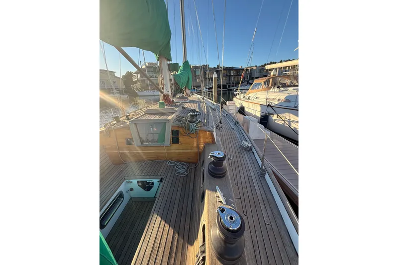 Slide: The Image of Chuck Burns Custom 49' Schooner, 2007, docked with sunlit wooden deck and green sails. - 22