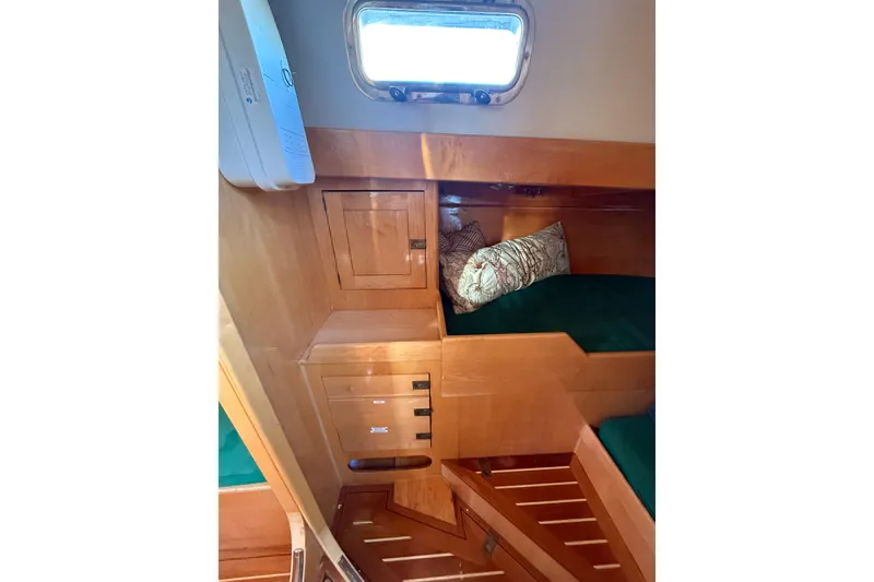Slide: The Image of Interior of 2007 Chuck Burns Custom 49' Schooner with wooden cabinetry and green bedding. - 30