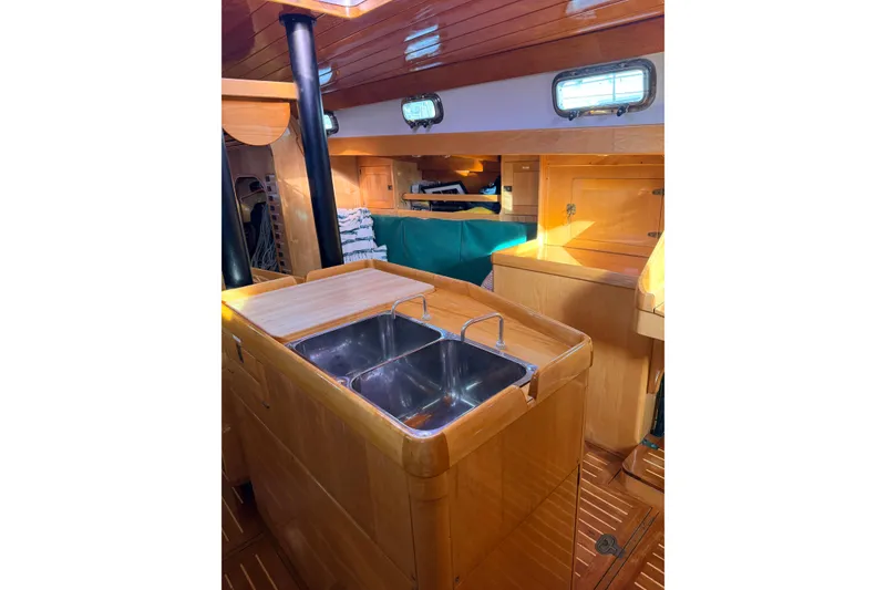 Slide: The Image of Interior of 2007 Chuck Burns Custom 49' Schooner with wooden cabinetry and stainless steel sink. - 37
