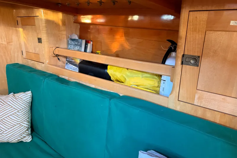 Slide: The Image of Interior of 2007 Chuck Burns Custom 49' Schooner with teal seating and wooden storage. - 41