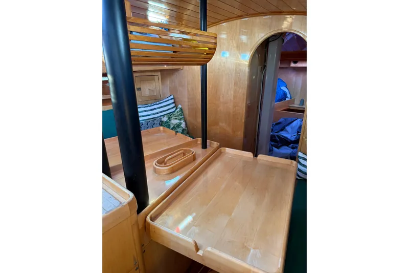 Slide: The Image of Interior of 2007 Chuck Burns Custom 49' Schooner with wooden furnishings and cozy decor. - 49